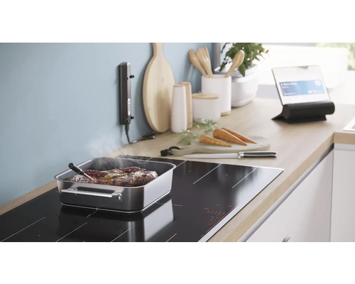 Küche mit Induktionskochfeld, Bräter, Fleischthermometer und Tablet