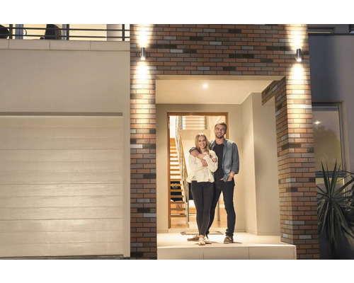 Modernes Haus mit Paar vor der Tür und Außenbeleuchtung