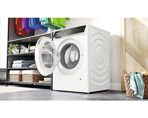 Weiße Waschmaschine mit geöffneter Tür in einem hellen Raum.