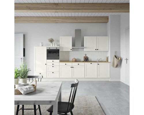 Helle Küche mit Einbaubackofen, Dunstabzugshaube und Esstisch