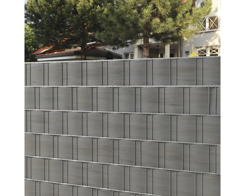 Grauer Sichtschutzzaun mit Drahtgitter vor einem Wohnhaus