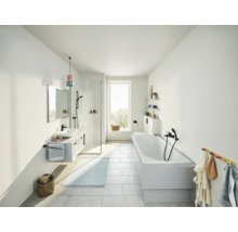 Helles Badezimmer mit Badewanne, Waschbecken, Spiegel und Dusche.