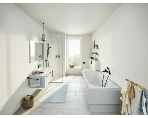Helles Badezimmer mit Badewanne, Waschbecken, Spiegel und Dusche.