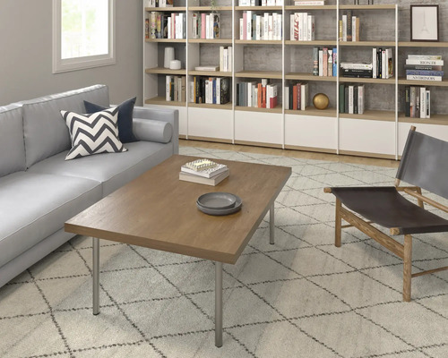 Wohnzimmer mit Sofa, Couchtisch, Regalen und Sessel