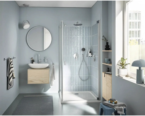 Helles Badezimmer mit Dusche, Waschtisch, Spiegel und Handtüchern