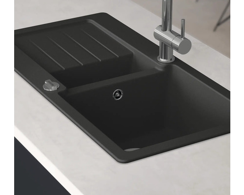 Schwarze Spüle mit Abtropffläche und Armatur