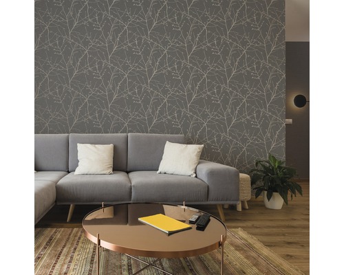 Wohnzimmer mit grauer Tapete mit Zweigmuster, grauem Sofa und rundem Tisch