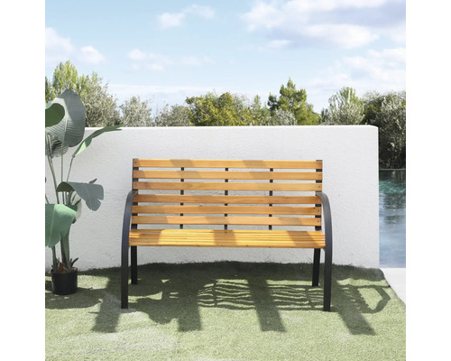 Gartenbank aus Holzlatten und schwarzem Metallgestell vor weißer Wand