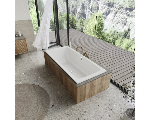 Badezimmer mit Badewanne, Waschtisch und Fensterfront mit Blick in die Natur