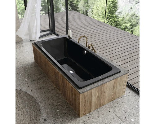 Schwarze Badewanne mit Holzverkleidung und Armaturen vor Fenster