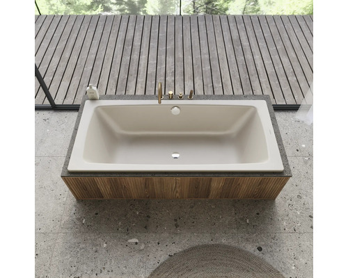 Eingebaute Badewanne mit Armaturen auf einer Holzverkleidung in einem Badezimmer