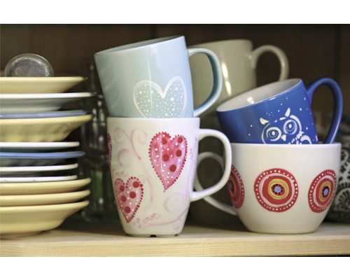 Gestapelte Tassen und Teller im Regal