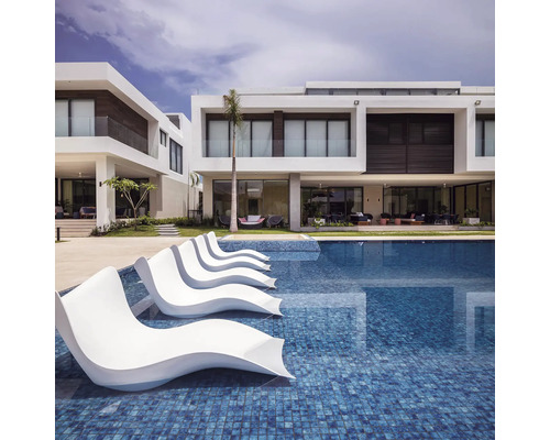 Schwimmbad mit Liegen und modernen Wohnhäusern im Hintergrund