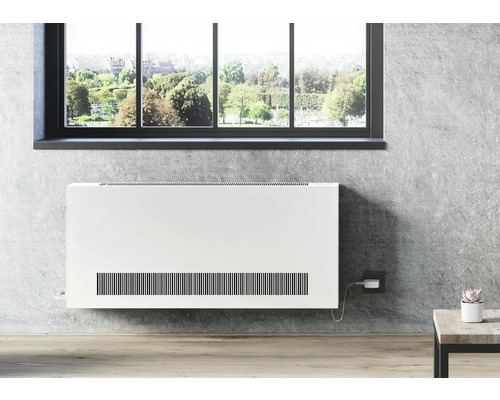 Flaches Heizgerät an der Wand unter dem Fenster mit Blick auf eine grüne Landschaft