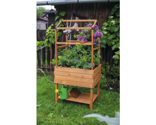 Hochbeet aus Holz mit Ablagefläche und Kräutern, Blumen und Knoblauch im Garten