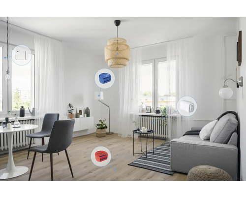 Heller Wohnraum mit Esstisch, Sofa und verschiedenen Smart Home Geräten