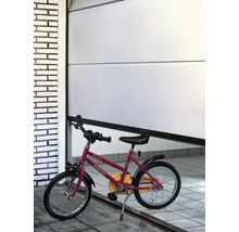Eine teilweise geöffnete weiße Garagentor mit einem Kinderfahrrad davor.