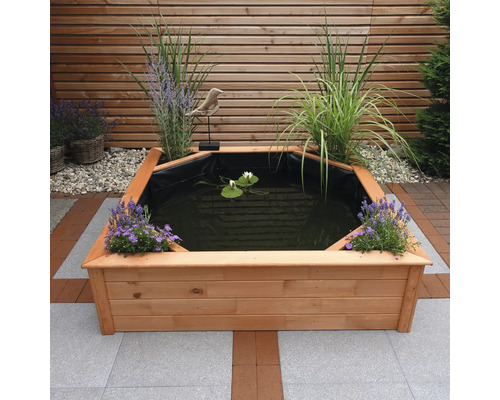 Holzteich mit Pflanzen und Seerosen im Garten