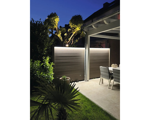 Beleuchteter Sichtschutzzaun im Garten mit Sitzbereich am Abend