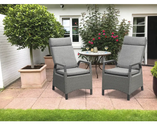 Zwei graue Gartenstühle mit hohen Rückenlehnen und Kissen auf einer Terrasse