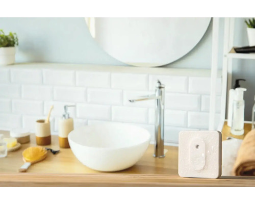 Badezimmer mit Waschbecken, Spiegel und Heizkörperthermostat