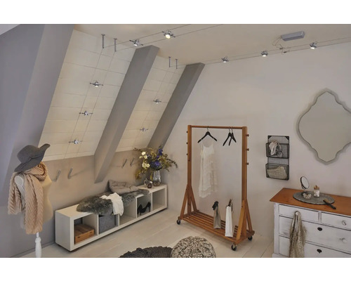 Helles Ankleidezimmer mit Kleiderständer, Kommode und flexibler Schienenbeleuchtung