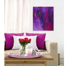 Wohnzimmer mit Sofa, Kissen, Tisch, Blumen, Kerze und abstrakter Kunst an der Wand