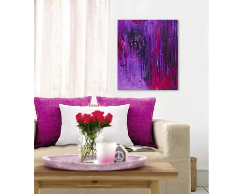 Wohnzimmer mit Sofa, Kissen, Couchtisch mit Rosen und abstraktem Gemälde an der Wand