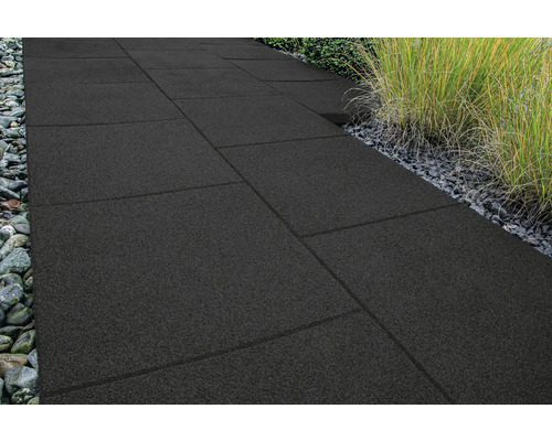 Weg aus dunklen Terrassenplatten mit Steinen und Pflanzen