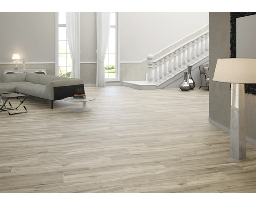 Heller Wohnraum mit Sofa, Treppe und Holzfliesen