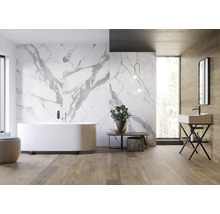 Helles Badezimmer mit Badewanne, Waschtisch, Spiegel und Marmorwand