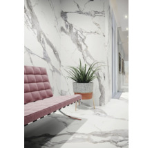 Innenraum mit rosa Sofa, Pflanze und Fliesen in Marmoroptik an Wand und Boden