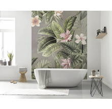 Badezimmer mit Badewanne und Fototapete mit tropischen Pflanzenmotiven.