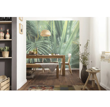 Esszimmer mit Holztisch, Stühlen und Wandbild mit Dschungelmotiv