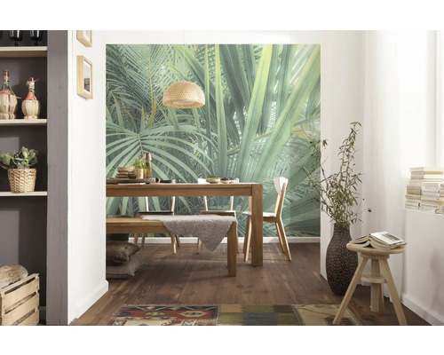 Esszimmer mit Holztisch, Stühlen und Wandbild mit Dschungelmotiv