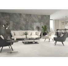 Heller Wohnraum mit Fliesenboden und Wandfliesen in Marmoroptik, Sofa und Sesseln