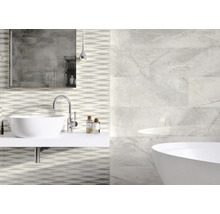 Badezimmer mit Waschbecken, Spiegel, Badewanne und Fliesen in Marmoroptik