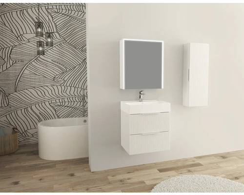 Badezimmer mit Waschbeckenunterschrank, Spiegel, Hängeschrank und Badewanne vor einer Wand mit Blattmuster