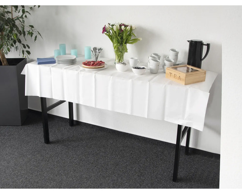 Tisch mit weißer Tischdecke, Geschirr, Getränken, Kuchen und Blumen