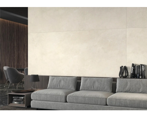 Heller Wohnraum mit großformatigen Wandfliesen, grauem Sofa und dunklen Holzdetails