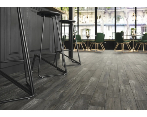 Innenraum mit grauem Laminatboden in Holzoptik und Barhockern
