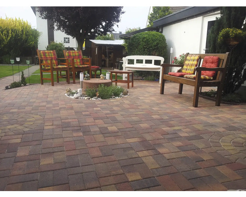 Gepflasterter Gartenbereich mit Gartenmöbeln und Dekorationen.