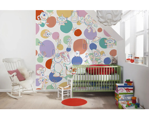 Dekoriertes Kinderzimmer mit Kinderbett, Schaukelstuhl und Tapete mit Cartoon-Motiven