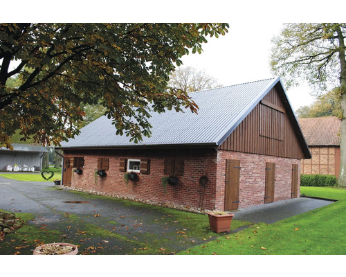 Ziegelgebäude mit Satteldach und Holzverkleidung auf einem Grundstück mit Bäumen