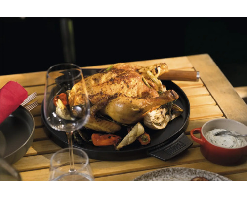 Gegrilltes Hähnchen auf Grillplatte mit Gemüse auf einem Holztisch