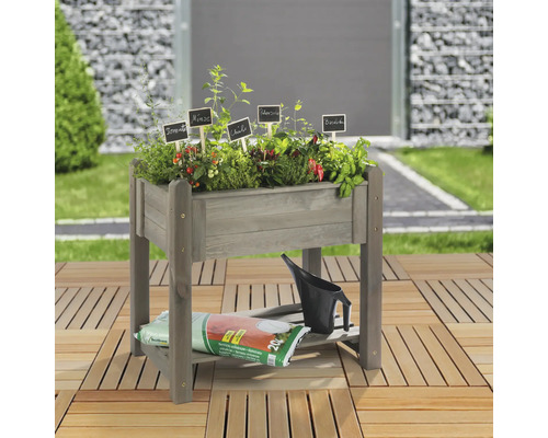 Hochbeet aus Holz mit Kräutern und Gemüse, Gießkanne und Erdsack