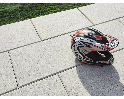 Helle Pflastersteine im Außenbereich mit einem Motorradhelm.