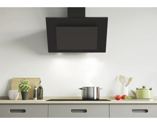 Küchenszene mit Dunstabzugshaube, Kochfeld und Küchenutensilien auf einer Arbeitsfläche.