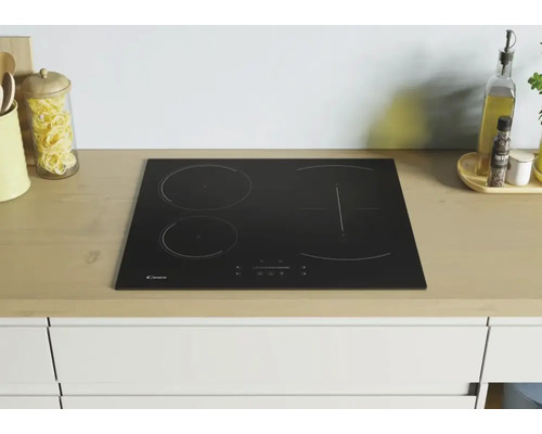 Schwarzes Candy Induktionskochfeld mit vier Kochzonen in einer Küchenzeile.