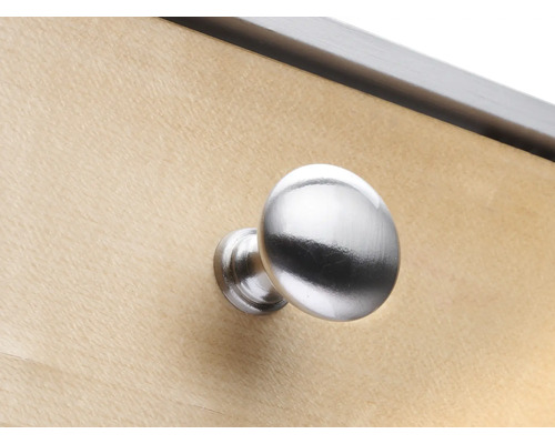 Runder Möbelknopf aus Metall an einer Holzoberfläche